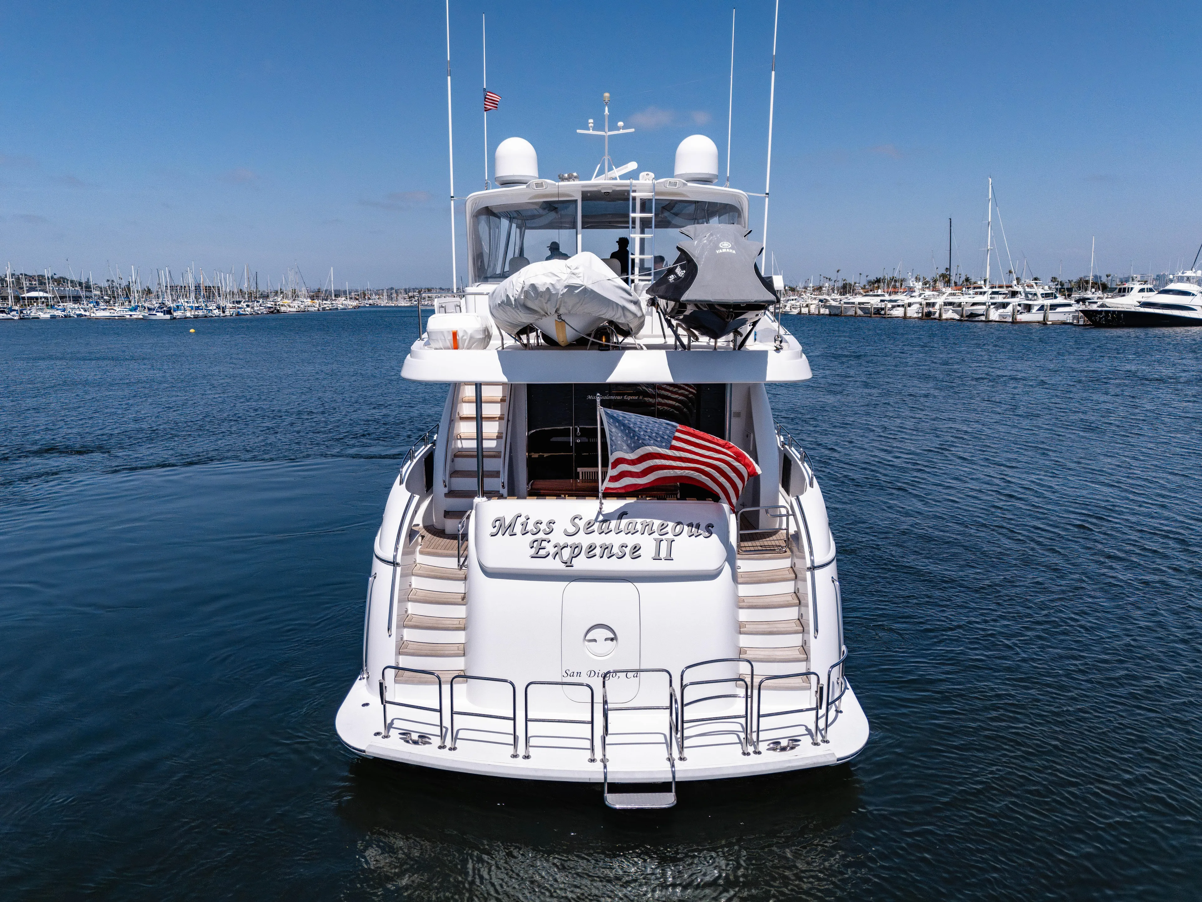 Miss Sealaneous Expense II Yacht Photos Pics 2008 Hatteras 72 Motor Yacht on calm water, rear view with American flag.