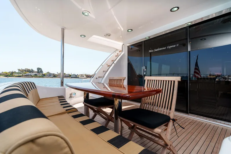 Miss Sealaneous Expense II Yacht Photos Pics 2008 Hatteras 72 Motor Yacht deck with striped seating, wooden table, and scenic water view.