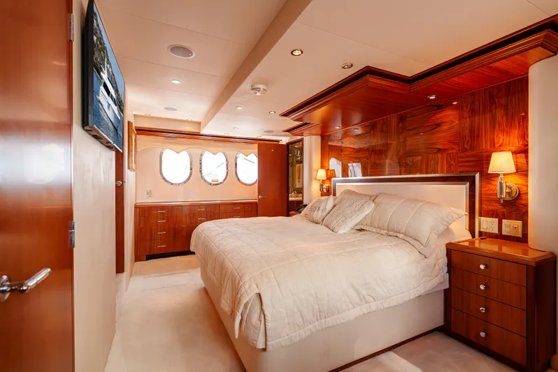 Miss Sealaneous Expense II Yacht Photos Pics Luxurious bedroom interior of 2008 Hatteras 72 Motor Yacht with elegant wood paneling.