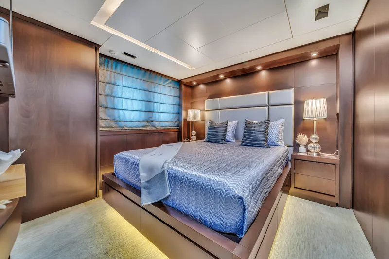  Yacht Photos Pics Luxurious bedroom interior on a 2012 Azimut 116 yacht, featuring elegant wood paneling.