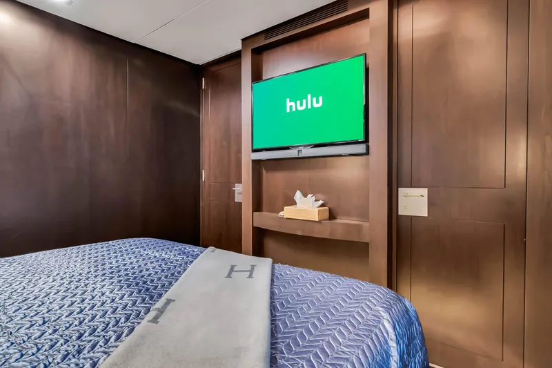  Yacht Photos Pics Luxurious Azimut 116 yacht bedroom with TV, 2012 model, featuring elegant wood paneling.