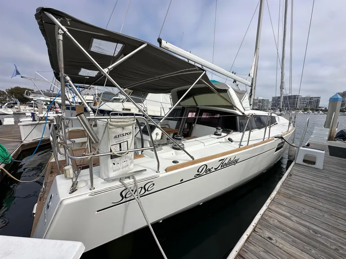 Doc Holiday Yacht Photos Pics 2012 Beneteau Sense 43 sailboat docked at marina, featuring canopy and lifebuoy.