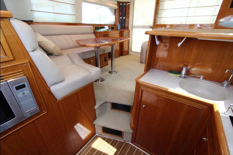  Yacht Photos Pics Interior of 2005 Riviera 46 Convertible Sportfisher with seating, table, and kitchenette.