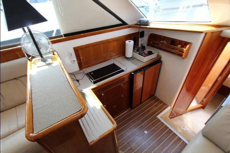  Yacht Photos Pics 2005 Riviera 46 Convertible Sportfisher interior with compact kitchen, wooden cabinetry, and modern appliances.