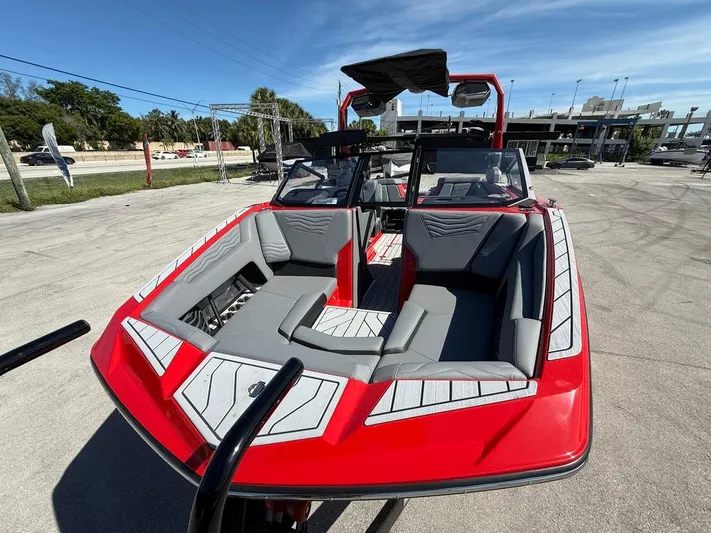  Yacht Photos Pics 2025 Nautique Super Air Nautique G23 boat, red exterior, gray seating, parked outdoors.