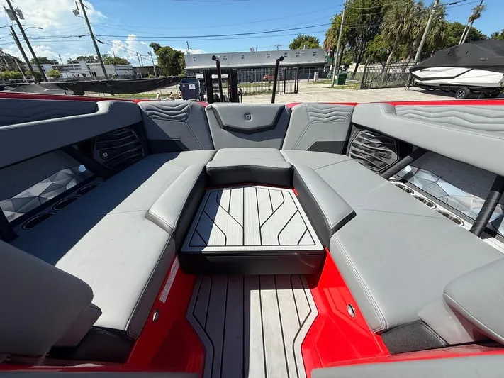  Yacht Photos Pics 2025 Nautique Super Air Nautique G23 interior with gray seating and red accents.