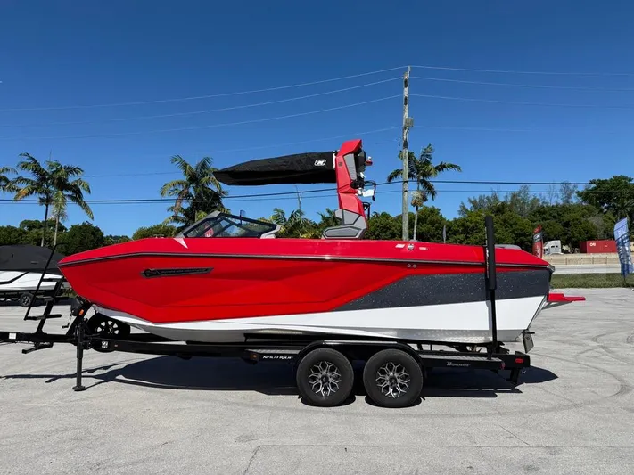  Yacht Photos Pics 2025 Nautique Super Air Nautique G23 boat in vibrant red on trailer, sunny day.