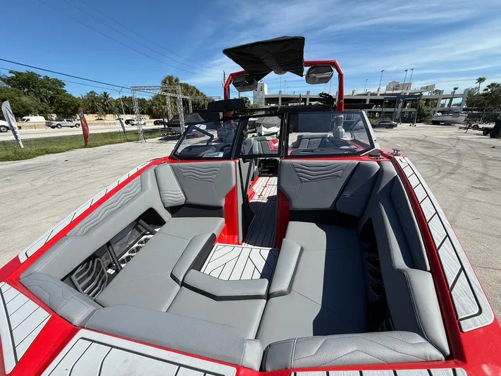  Yacht Photos Pics 2025 Nautique Super Air Nautique G23 boat interior with gray seating and red accents.