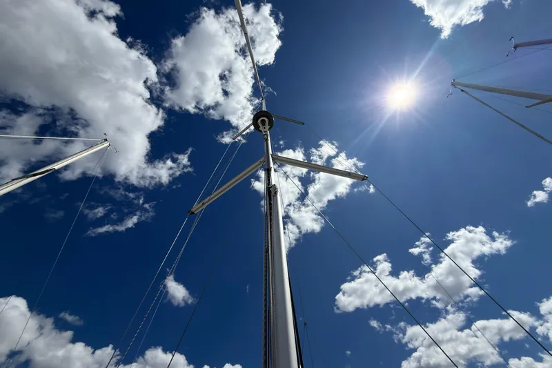 Wind Waker Yacht Photos Pics Sailboat mast of 2013 Beneteau Oceanis 41 against a sunny, cloudy sky.