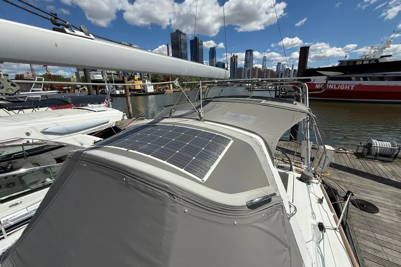 Wind Waker Yacht Photos Pics Beneteau Oceanis 41 sailboat with solar panel, docked in a marina, city skyline background.