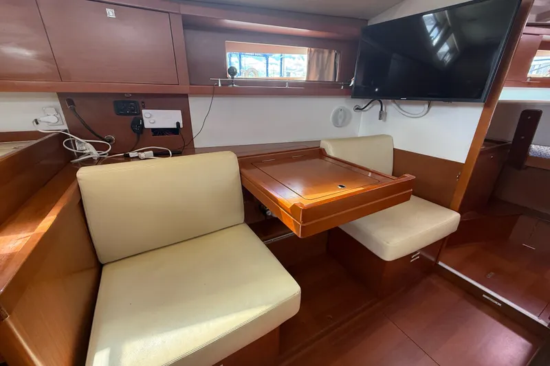 Wind Waker Yacht Photos Pics Interior of 2013 Beneteau Oceanis 41 yacht with seating, table, and mounted TV.