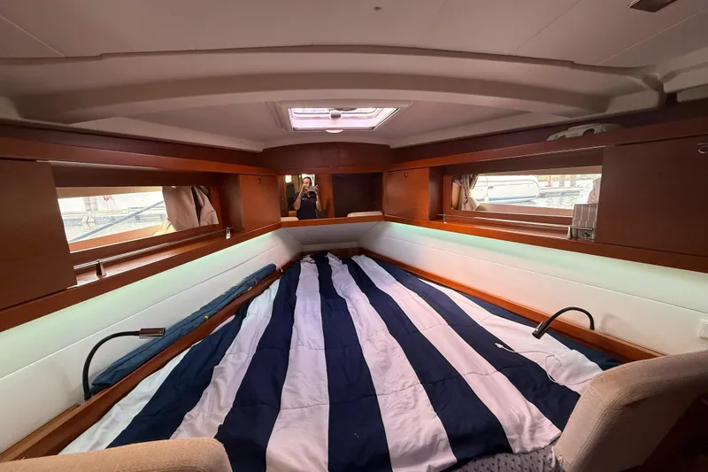 Wind Waker Yacht Photos Pics Interior cabin of 2013 Beneteau Oceanis 41 sailboat with striped bedding and wood accents.