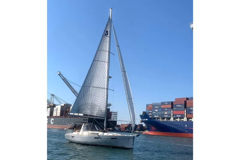 Wind Waker Yacht Photos Pics Sailing yacht Beneteau Oceanis 41, 2013 model, cruising near container ships in a busy port.