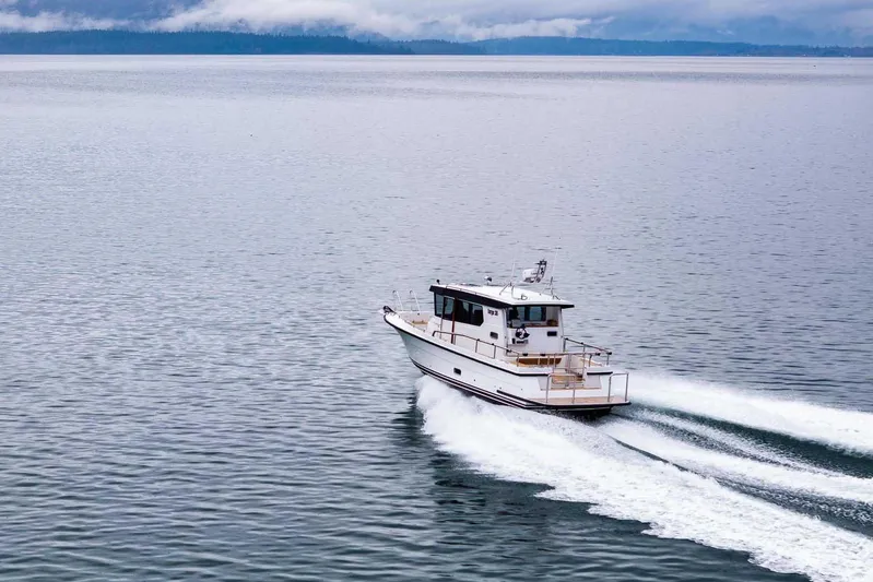  Yacht Photos Pics 2024 Targa 30.1 boat cruising on calm waters with scenic background.