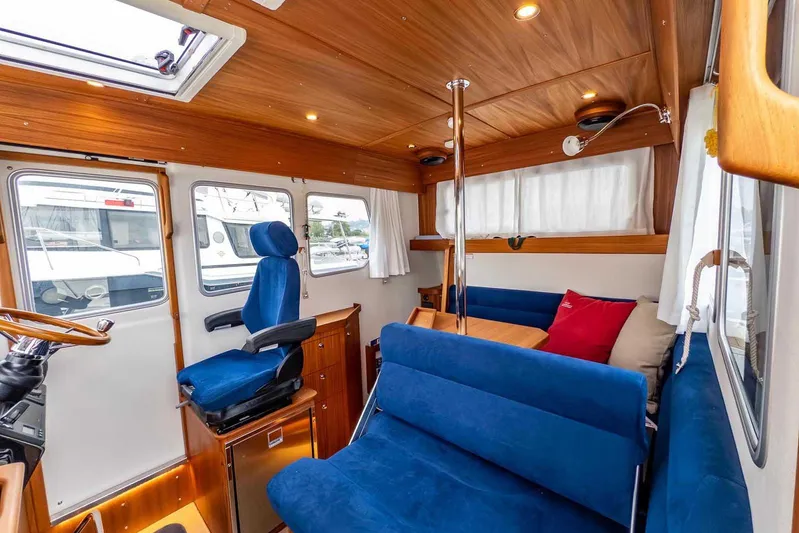  Yacht Photos Pics 2024 Targa 30.1 boat interior with blue seating, wooden accents, and natural light.