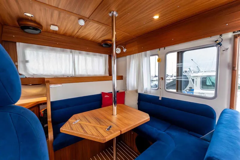  Yacht Photos Pics 2024 Targa 30.1 boat interior with blue seating and wooden table.