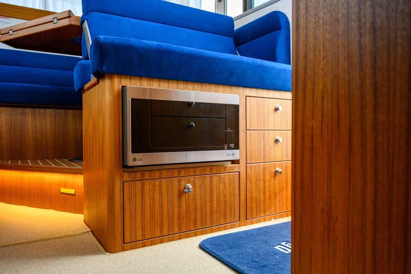  Yacht Photos Pics 2024 Targa 30.1 interior with blue seating, wood cabinetry, and built-in LG microwave.