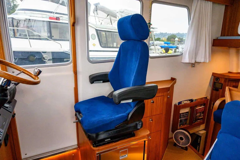  Yacht Photos Pics 2024 Targa 30.1 boat interior with blue captain's chair and wooden cabinetry.