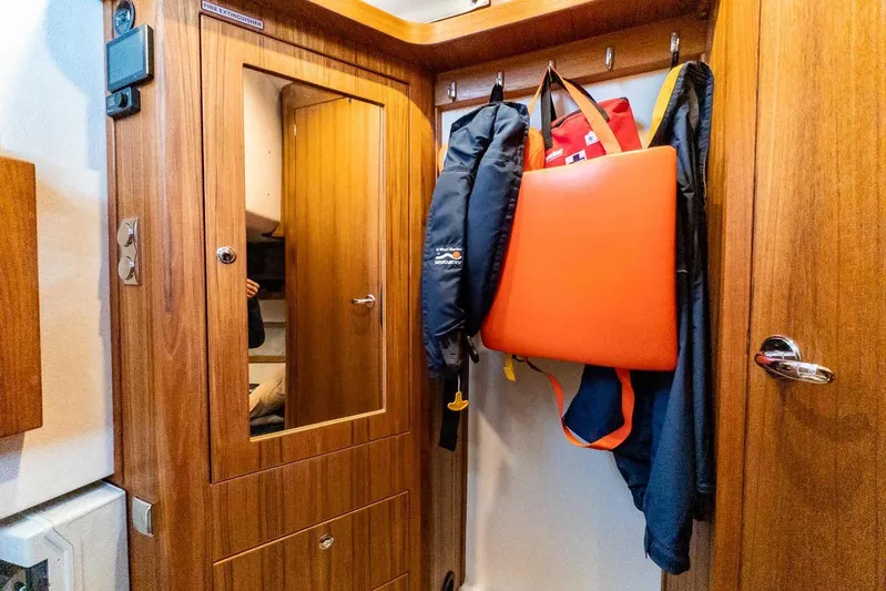  Yacht Photos Pics 2024 Targa 30.1 interior with wooden cabinetry and hanging jackets.