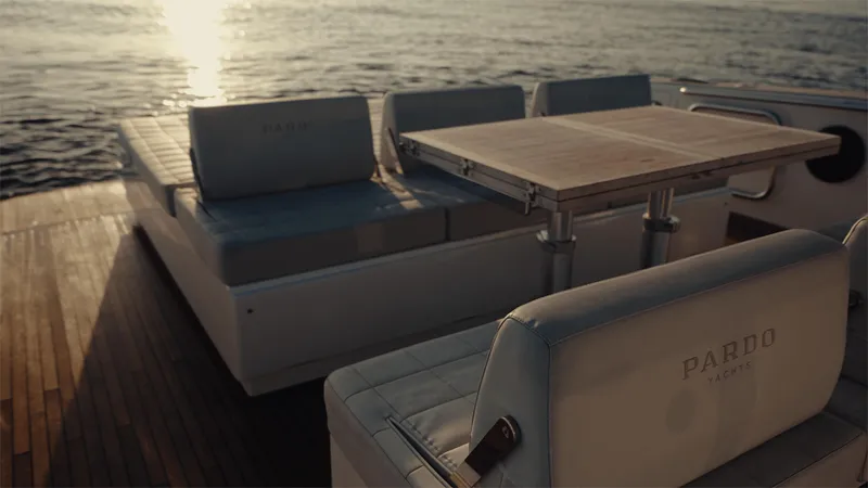 Mea Yacht Photos Pics Luxurious 2022 Pardo Yachts 43 deck with seating and table, overlooking serene ocean view.