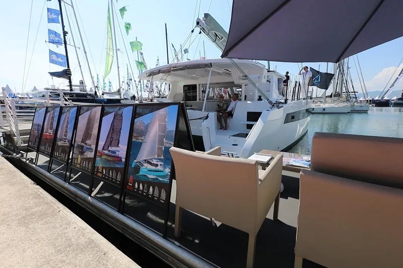 Lasai Yacht Photos Pics 2023 Balance 442 yacht displayed at marina with promotional posters and seating area.
