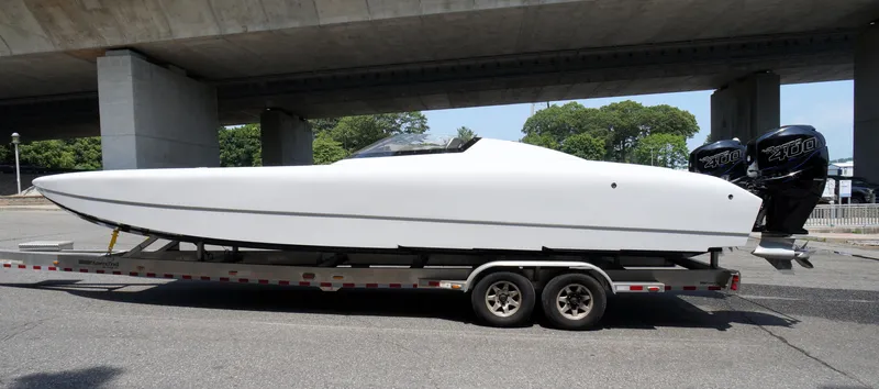  Yacht Photos Pics 2005 Doug Wright 32 powerboat on trailer under bridge, featuring twin outboard engines.