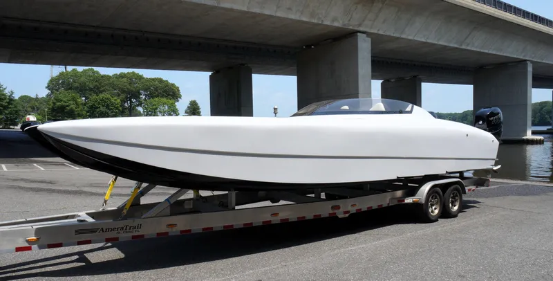  Yacht Photos Pics 2005 Doug Wright 32 boat on trailer under bridge, parked near water.