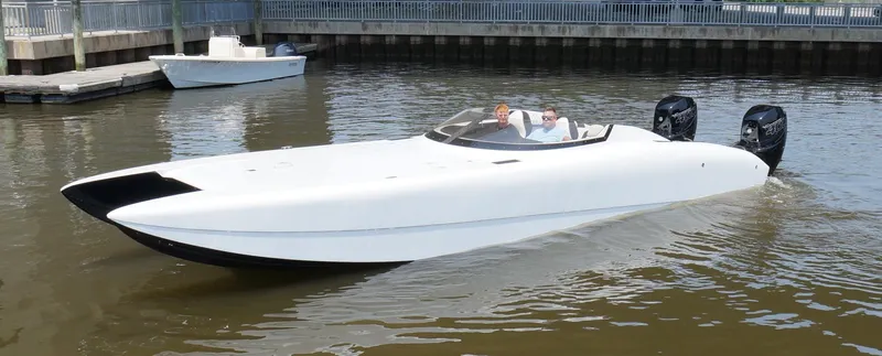  Yacht Photos Pics A sleek 2005 Doug Wright 32 powerboat cruising on calm waters near a dock.