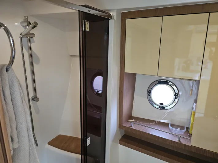  Yacht Photos Pics Bathroom interior of 2015 Beneteau Gran Turismo 49 yacht, featuring shower and porthole window.