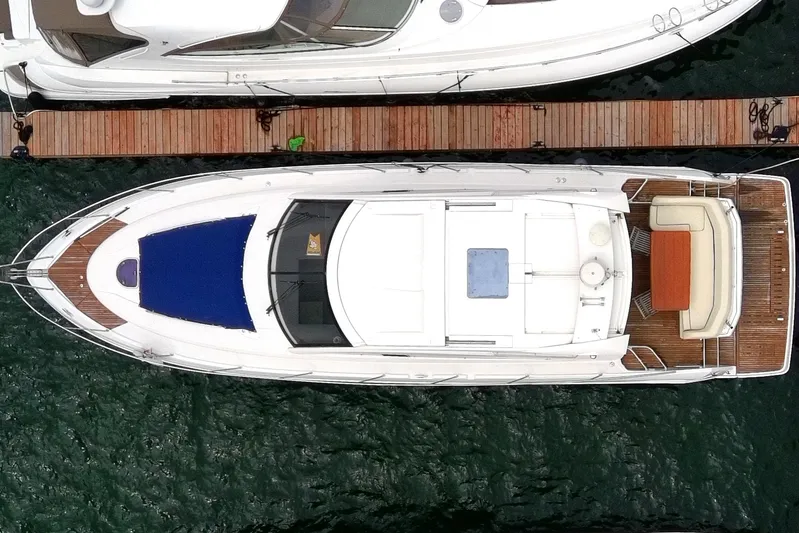  Yacht Photos Pics Aerial view of 2015 Beneteau GRAN TURISMO 49 yacht docked at a wooden pier.