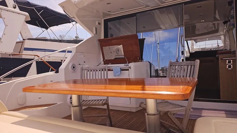  Yacht Photos Pics 2015 Beneteau Gran Turismo 49 yacht with outdoor dining area and wooden table.