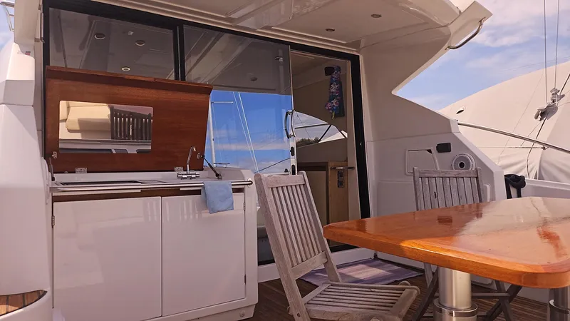  Yacht Photos Pics 2015 Beneteau Gran Turismo 49 yacht deck with dining area and kitchenette.