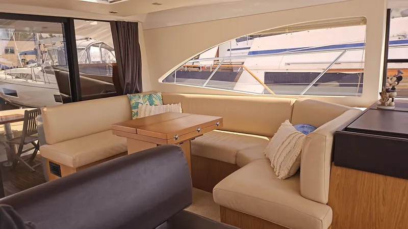  Yacht Photos Pics Interior of 2015 Beneteau Gran Turismo 49 yacht with beige seating and wooden table.