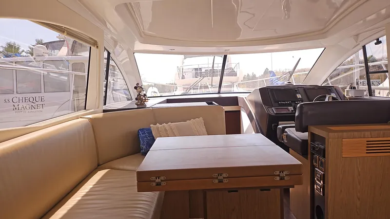  Yacht Photos Pics Interior of 2015 Beneteau Gran Turismo 49 yacht, featuring a cozy seating area and helm.