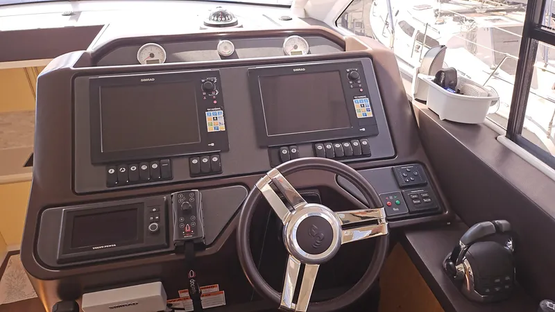  Yacht Photos Pics Control panel of 2015 Beneteau Gran Turismo 49 yacht with navigation screens and steering wheel.