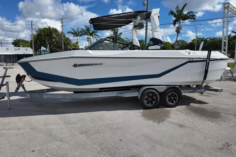  Yacht Photos Pics 2025 Nautique Super Air Nautique G25 boat on trailer, parked outdoors under blue sky.