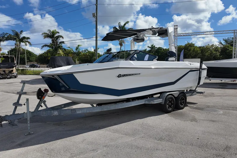  Yacht Photos Pics 2025 Nautique Super Air Nautique G25 boat on trailer, parked outdoors under blue sky.