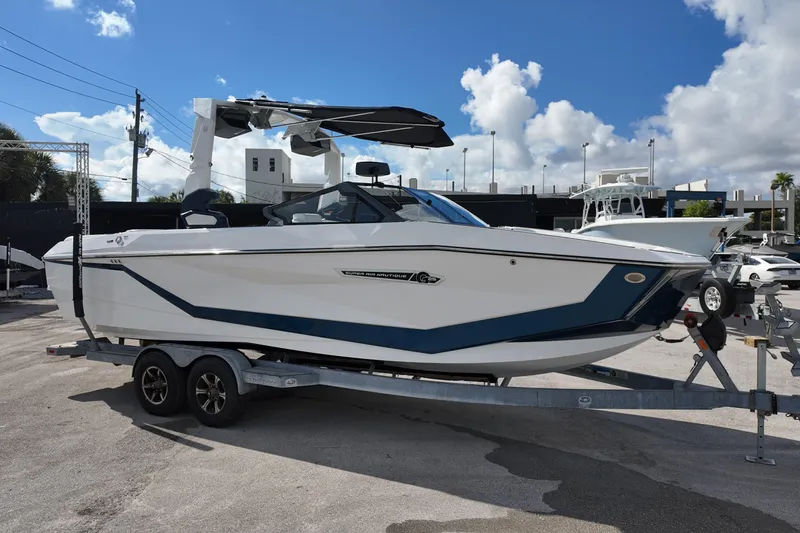  Yacht Photos Pics 2025 Nautique Super Air Nautique G25 boat on trailer under blue sky.