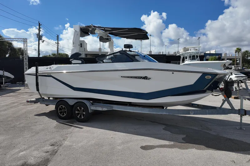  Yacht Photos Pics 2025 Nautique Super Air Nautique G25 boat on trailer under blue sky.