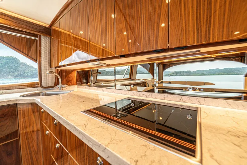 El Lobo Yacht Photos Pics Luxurious kitchen interior of 2020 Viking 58 Convertible yacht with wood cabinetry and modern appliances.