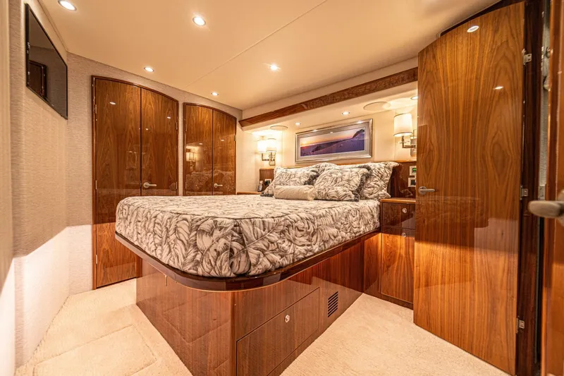 El Lobo Yacht Photos Pics Luxurious bedroom interior of 2020 Viking 58 Convertible yacht with elegant wood finishes.