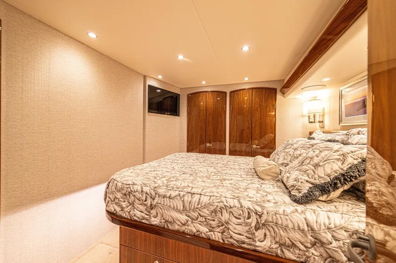 El Lobo Yacht Photos Pics Luxurious bedroom interior of 2020 Viking 58 Convertible yacht with elegant bedding and warm lighting.