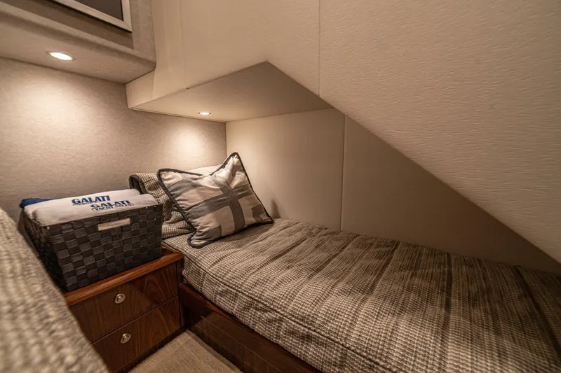El Lobo Yacht Photos Pics Cozy cabin interior of 2020 Viking 58 Convertible yacht with bed and storage basket.