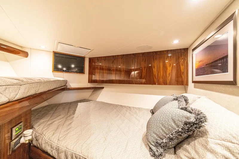 El Lobo Yacht Photos Pics Luxurious cabin interior of 2020 Viking 58 Convertible yacht with cozy bedding and elegant wood finishes.