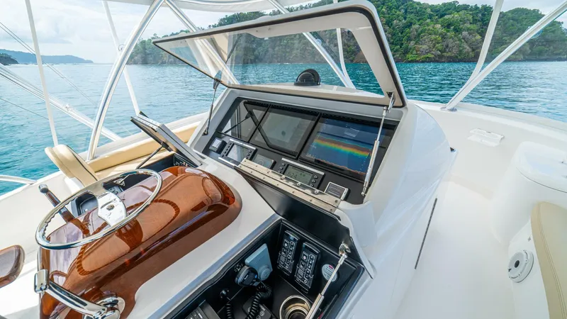 El Lobo Yacht Photos Pics 2020 Viking 58 Convertible yacht helm with advanced navigation system, steering wheel, and ocean view.
