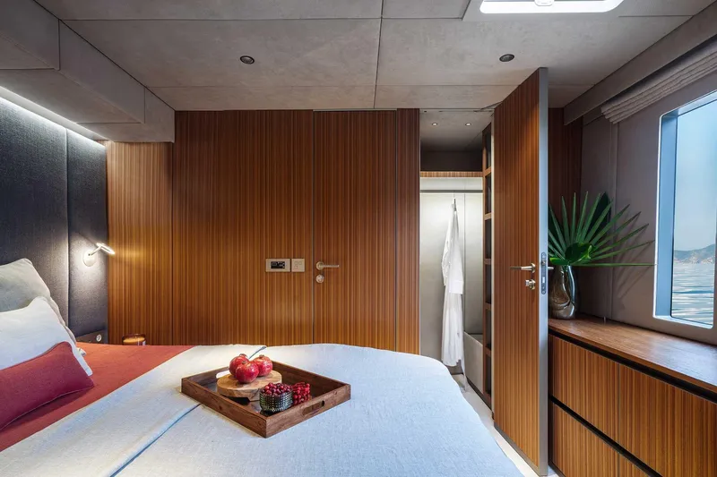 Candy Yacht Photos Pics Luxurious Sunreef 70 yacht bedroom interior with wooden accents and ocean view, 2021 model.