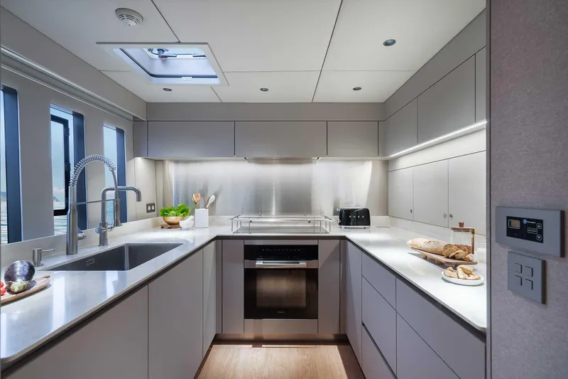 Candy Yacht Photos Pics Modern kitchen interior on 2021 Sunreef 70 yacht, featuring sleek cabinetry and stainless steel appliances.