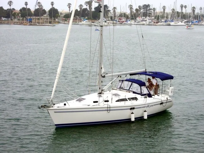 Alcyone Yacht Photos Pics 2007 Catalina 350 sailboat on calm water with marina background.