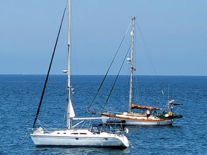 Alcyone Yacht Photos Pics Two sailboats anchored on a calm sea, featuring a 2007 Catalina 350.
