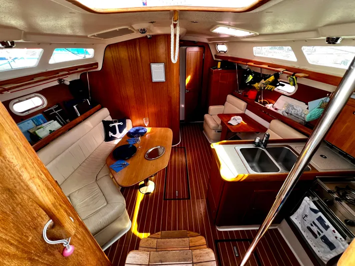 Alcyone Yacht Photos Pics Interior of a 2007 Catalina 350 sailboat with cozy seating and wooden finishes.